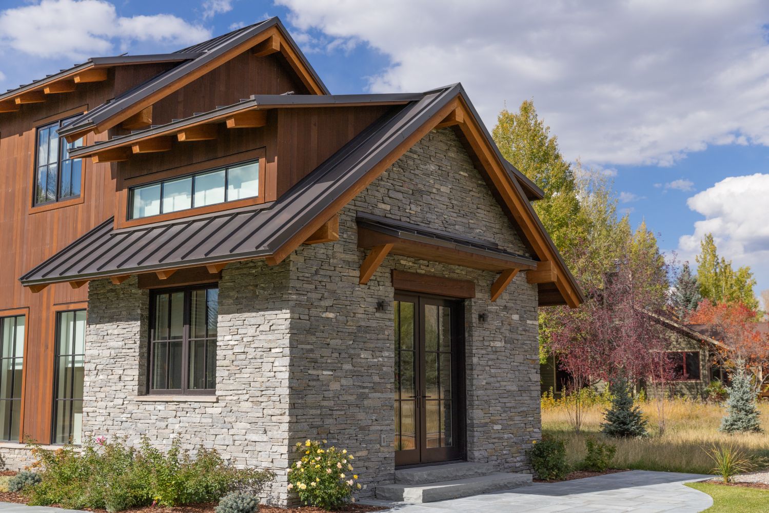 Contemporary house with mixed wood and stone exterior design.